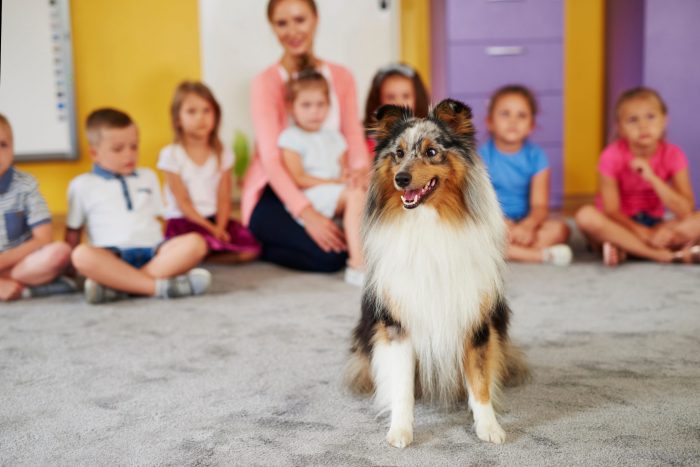 group of children sitting around happy dog